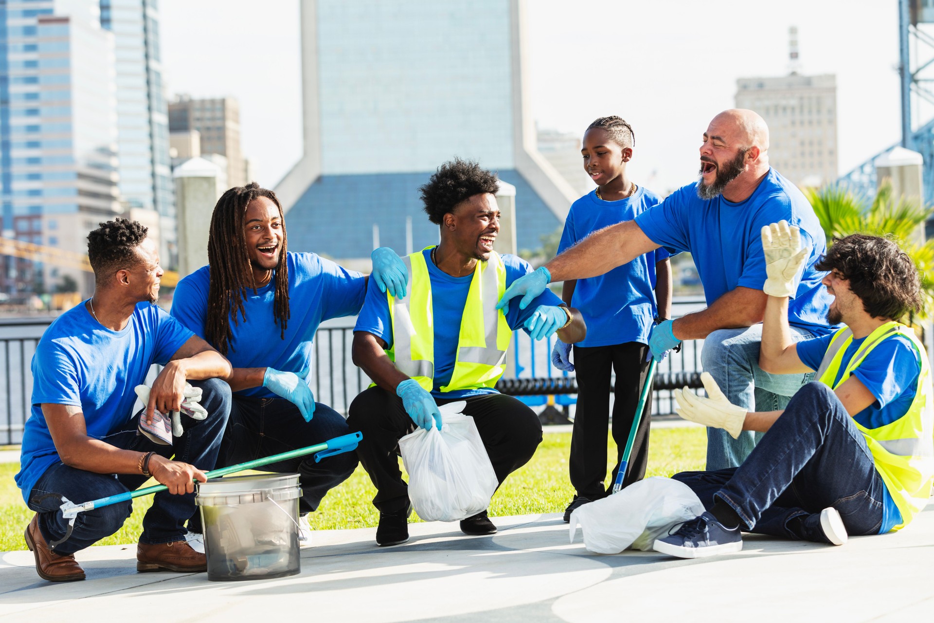 Group of men volunteers picking up litter in city park